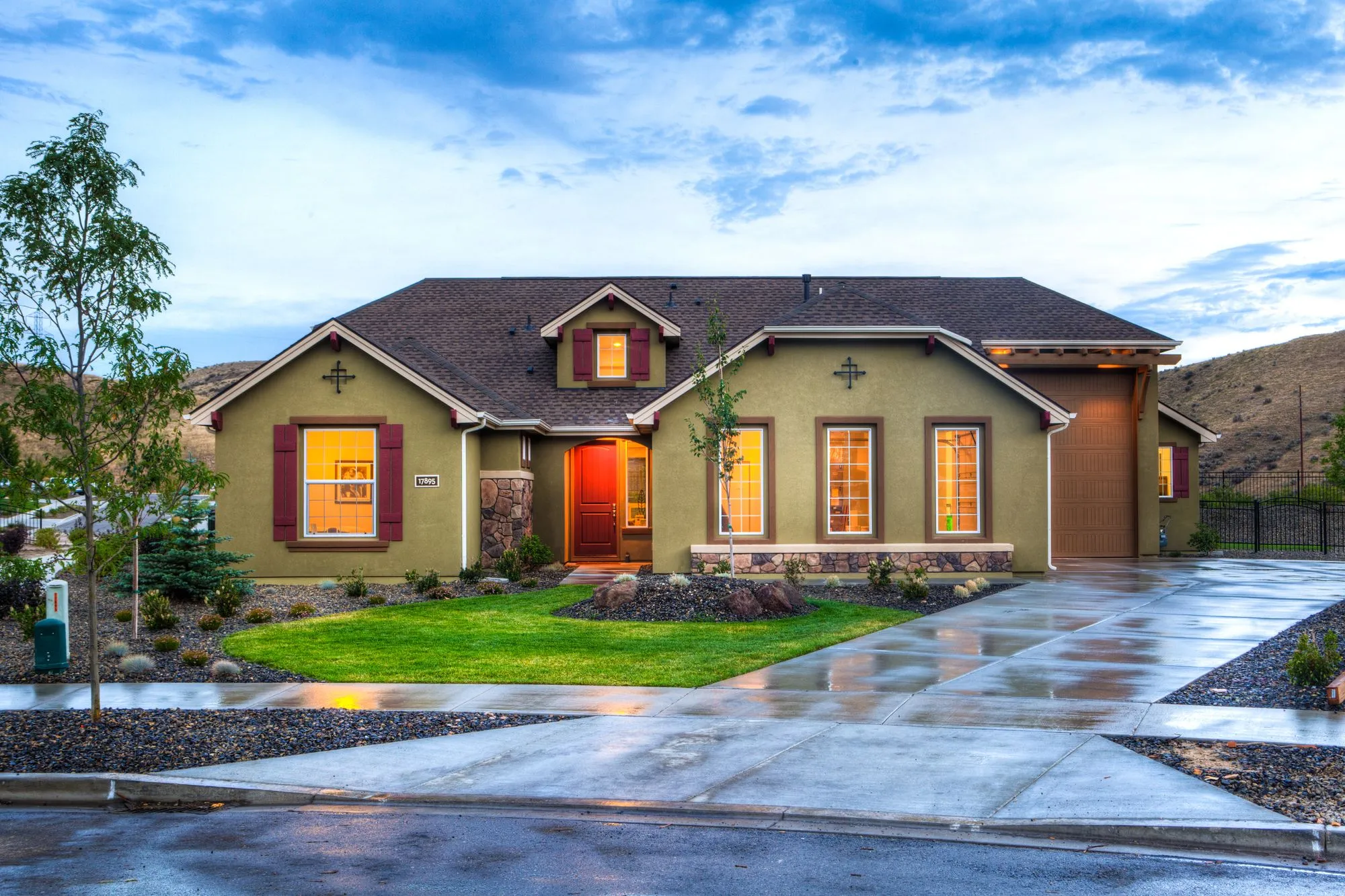 A white two-story home with a green front lawn
